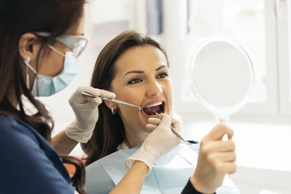 a patient is cheching her teeth after veneers treatment